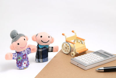 Close-up of toys on table against white background