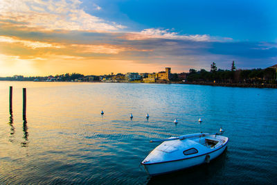 Boats in sea at sunset