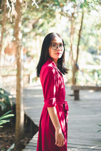 Portrait of woman standing against tree