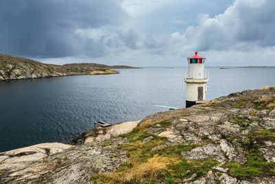 Lighthouse by sea against sky