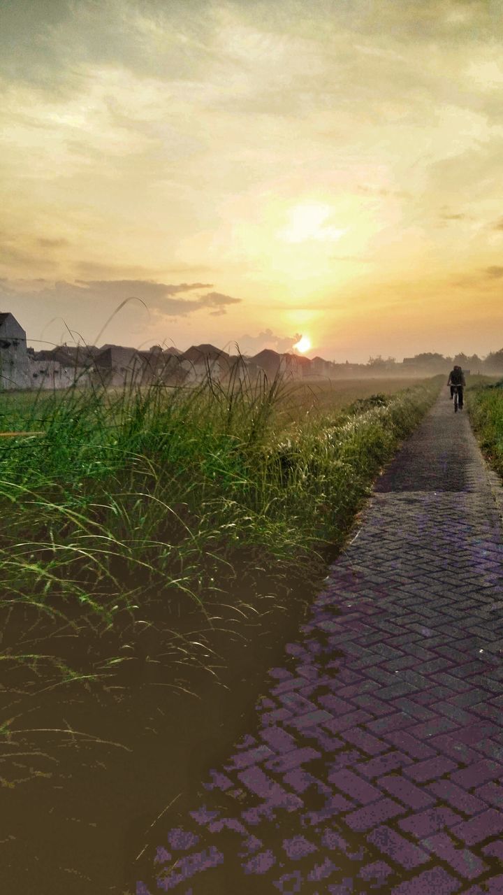 FOOTPATH AMIDST FIELD AGAINST SKY DURING SUNSET