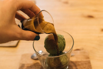 Midsection of person pouring drink in glass