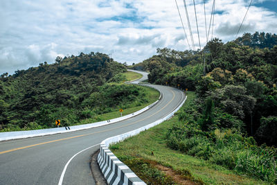 Road amidst trees against sky