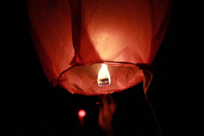 Close-up of illuminated lantern over black background