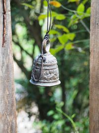 Close-up of an antique silver door bell hanging tropical green background