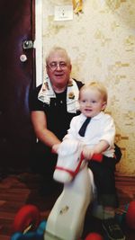 Full length of father and daughter sitting outdoors