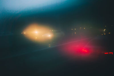 Light trails on road against sky at night