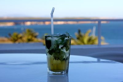 Close-up of drink on table against sea