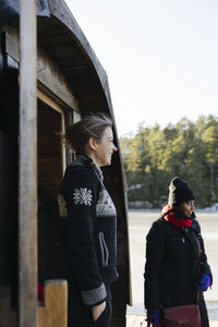 Smiling woman standing in front of sauna