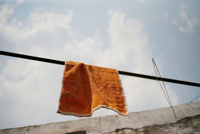 Low angle view of clothes drying on clothesline against sky