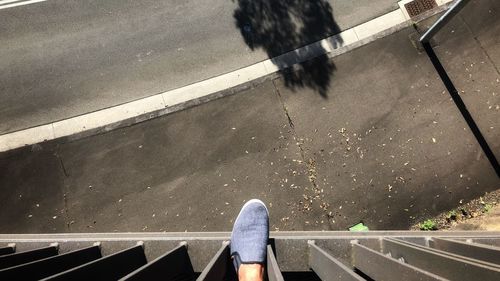 Low section of man walking on road