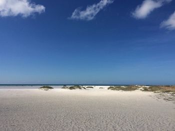 Scenic view of beach against blue sky