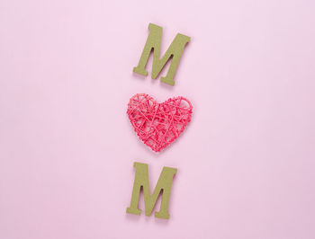 High angle view of heart shape made on pink background