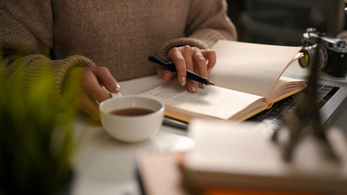 Midsection of woman reading book