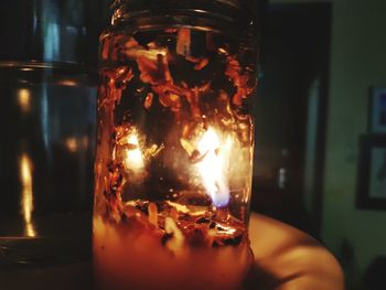 Close-up of burning candle on table