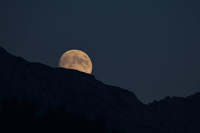 Low angle view of silhouette mountain against sky at night