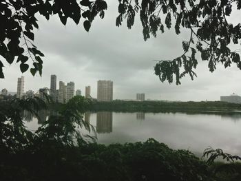 Scenic view of lake by buildings against sky