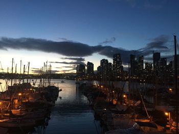 Boats moored in harbor at dusk