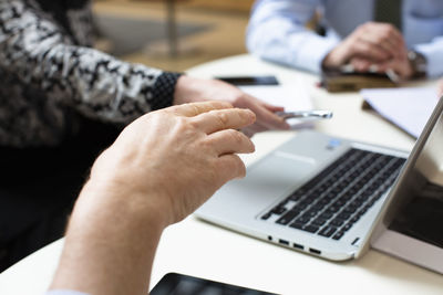 Midsection of man using laptop on table