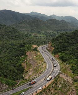 High angle view of vehicles on road by mountain against sky