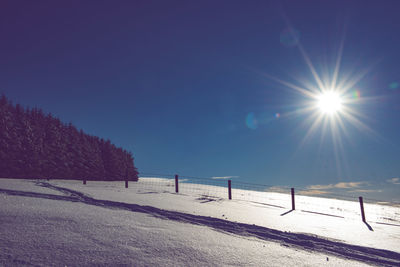 Scenic view of snow covered field against clear blue sky