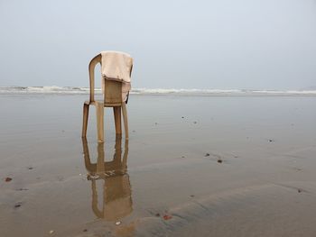 Wooden posts on beach against sky