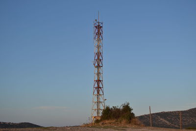 Low angle view of communications tower against clear blue sky