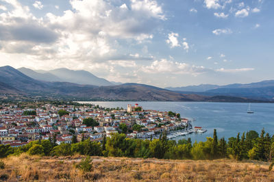 Scenic view of townscape by mountains against sky