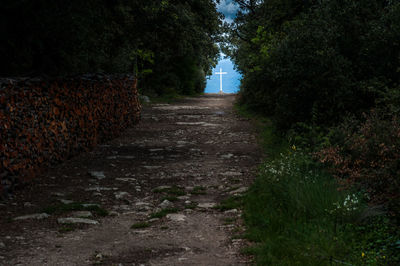 Road leading towards cross at beach