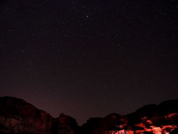 Low angle view of silhouette mountain against star field