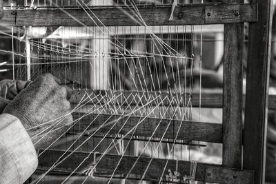 Cropped hands of man working in loom