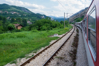 Railroad tracks by mountain against sky