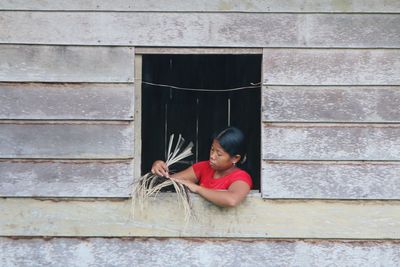 Woman holding plants on window