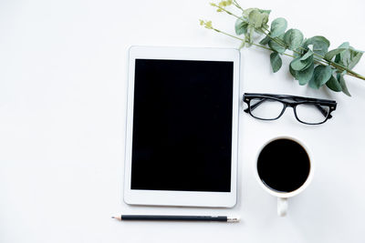 Directly above shot of laptop on table against white background