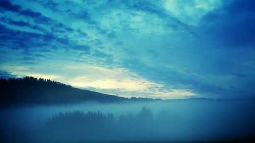 Scenic view of mountains against cloudy sky