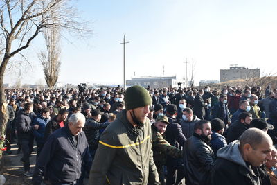 Group of people standing in town square against clear sky