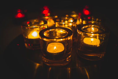 Close-up of illuminated tea light candles on table
