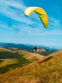 Rear view of person paragliding against sky