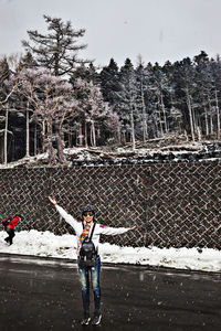 Rear view of woman standing on road