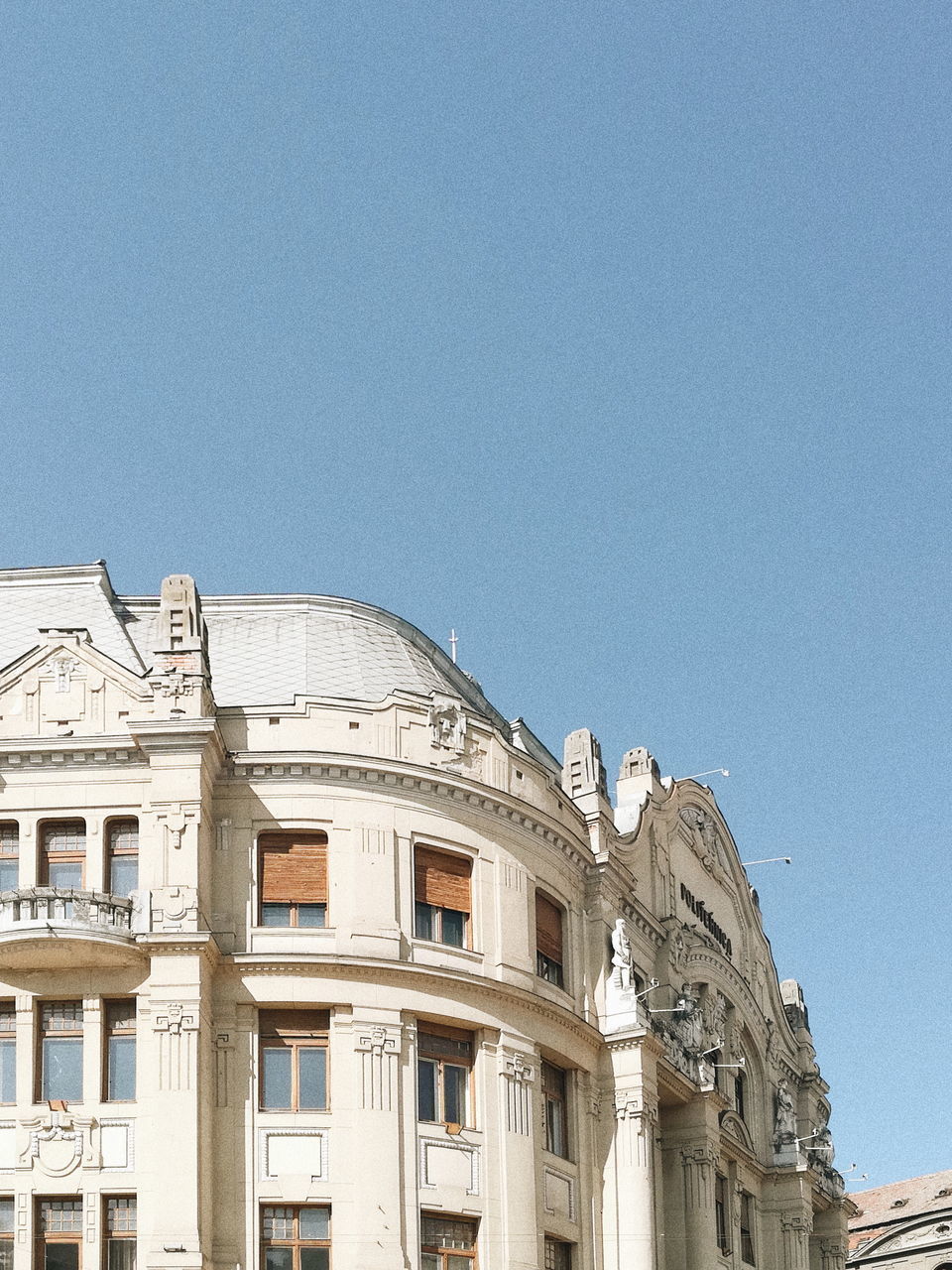 LOW ANGLE VIEW OF BUILDINGS AGAINST CLEAR BLUE SKY