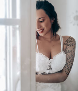 Portrait of young woman looking through window