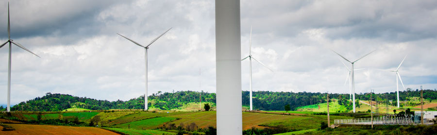 Windmills on field against sky