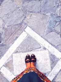 Low section of woman standing on tiled floor