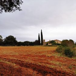 Built structure on field against cloudy sky