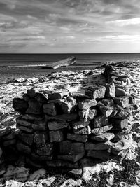 Stack of rocks on beach against sky