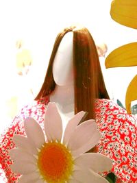 Close-up of daisy flowers and woman standing by flowering plants