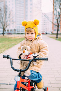 A small child learns to ride a bike for the first time in the city in spring