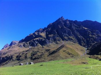 Scenic view of mountains against clear blue sky