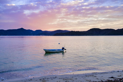 Boat in sea against sky during sunset