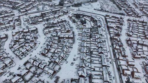Aerial view of snow covered houses in city during winter